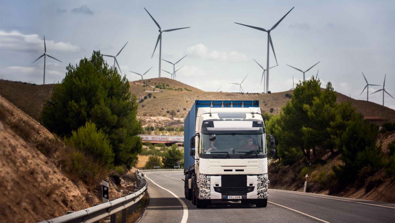 Samochód ciężarowy na drodze w Hiszpanii, w tyle turbiny wiatrowe